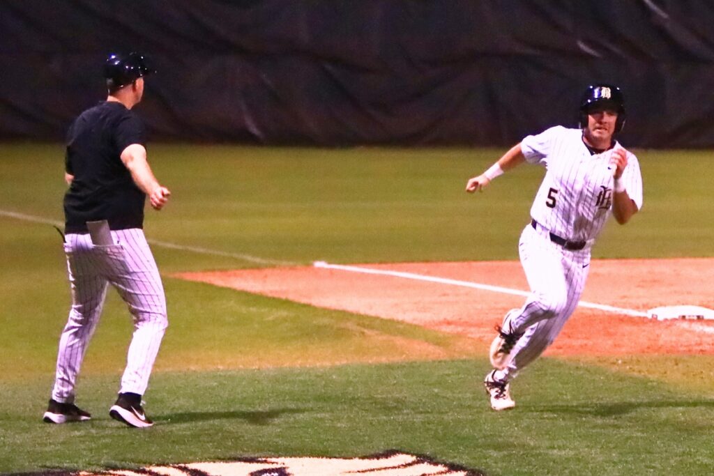 Buchholz coach Chris Malphurs waves in Roen Kresak (5) to score and put the Bobcats up 10-0 in the second inning against Suwannee. Photo by C.J. Gish