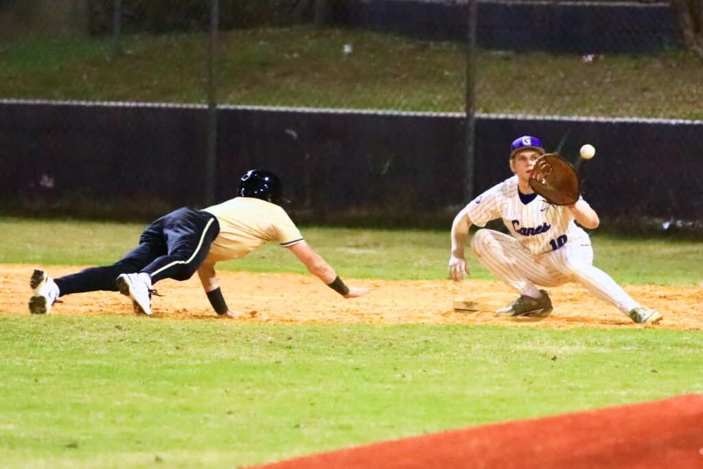 Buchholz's Aidan Kastensmidt (2) dives back to first base and avoids the tag by Gainesville's Connor Kemph (10). Photo by C.J. Gish