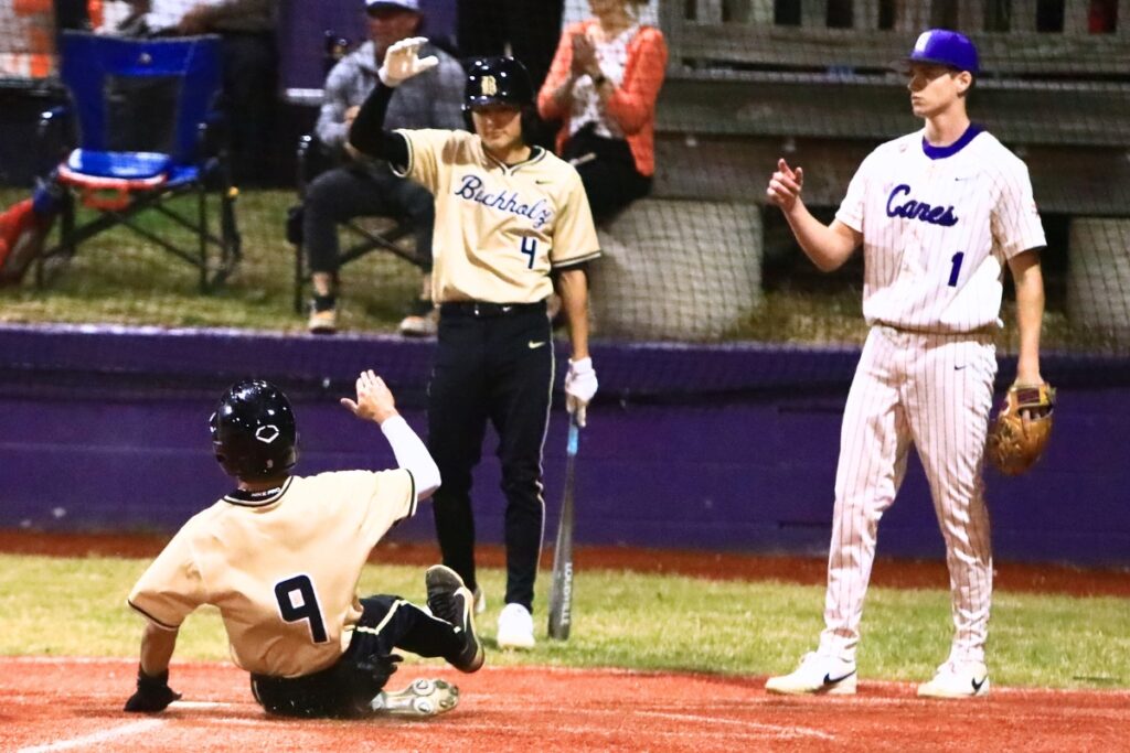 Buchholz's Angel Irizarry (9) slides into home plate for a 2-1 lead over Gainesville in the top of the fifth inning. Photo by C.J. Gish