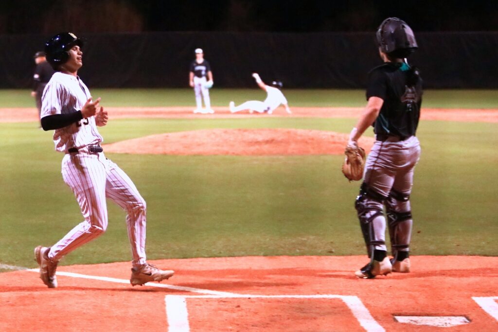 Buchholz's Antoine Deleyrolle (23) scores on a two-run double in the second inning against Suwannee. Photo by C.J. Gish