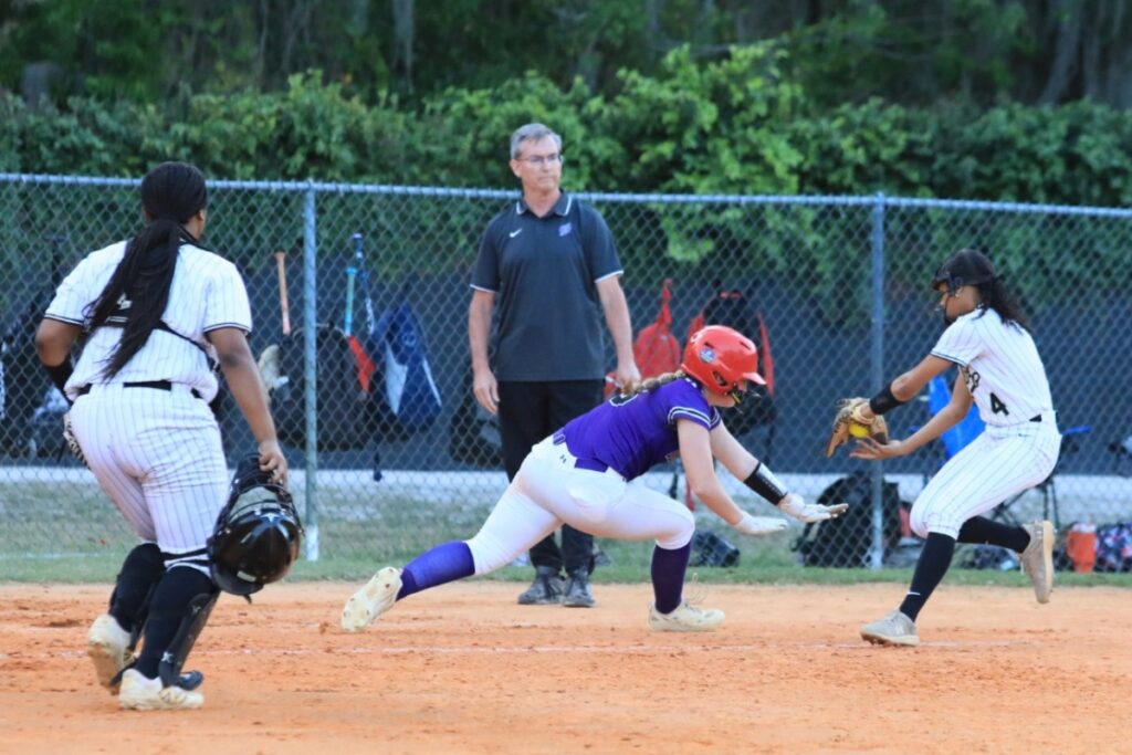 Buchholz's Jordyn Cooper tags a Gainesville runner out at third base after getting caught on her way to home plate. Photo by Seth Johnson