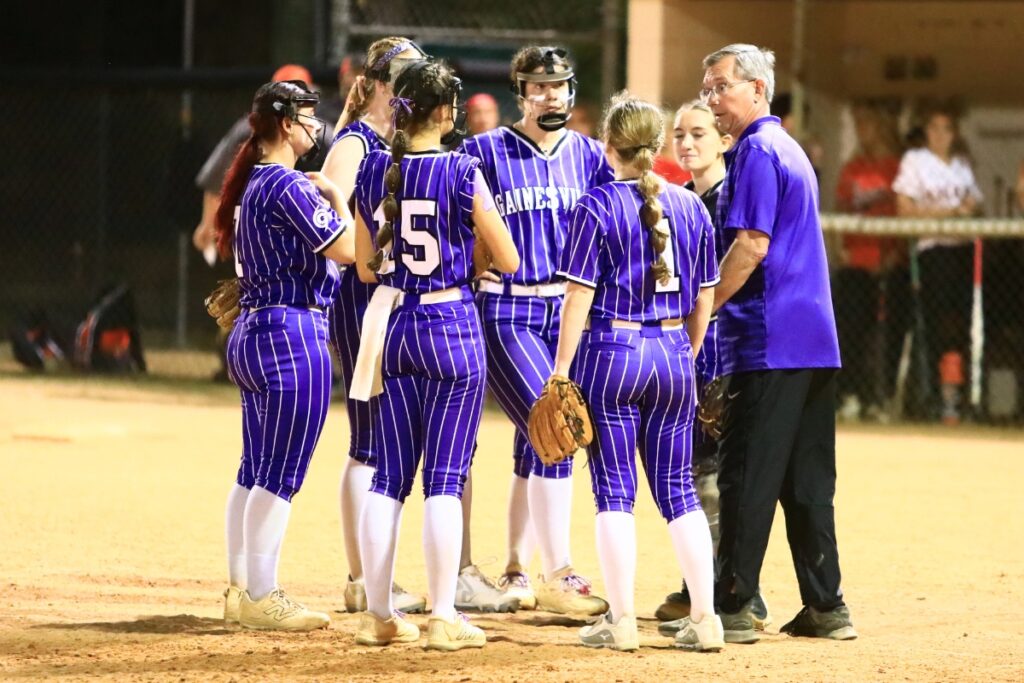 Gainesville coach Chris Chronister (right) talks defensive strategy in the top of the seventh inning with Trenton runners on second and third base and one out. Photo by C.J. Gish