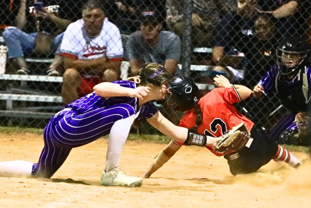 Gainesville's Leanna Bourdage (14) tags out Trenton's Lexi Faught (12) just before she reaches home plate in the top of the eighth inning. Photo by C.J. Gish 1 (1)