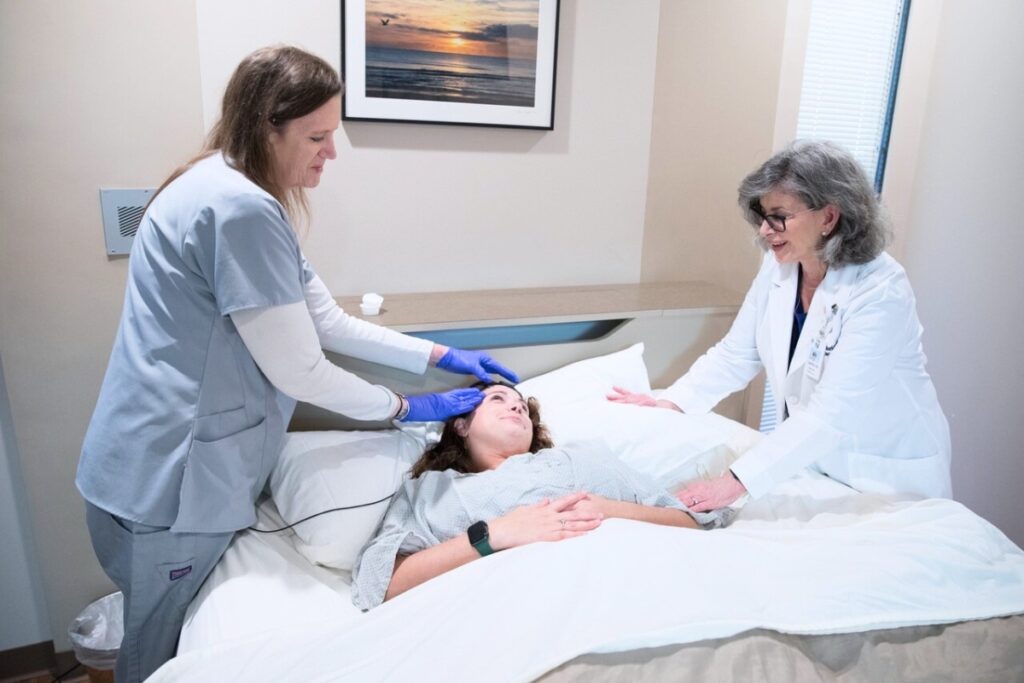 HCA Florida North Florida Hospital Sleep Center Manager Carolyn Ivey, and another sleep center colleague, prep a patient for a sleep study.