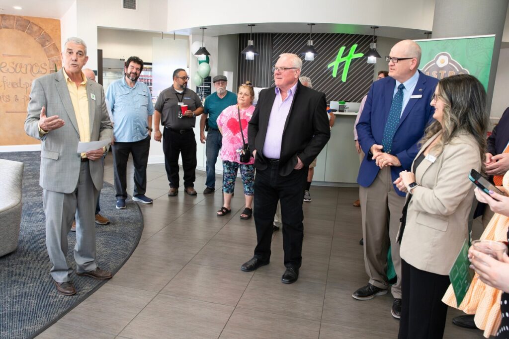 Hotel general manager Aksas Alouani, left, outlines the property’s renovations for guests gathered in the revamped lobby.