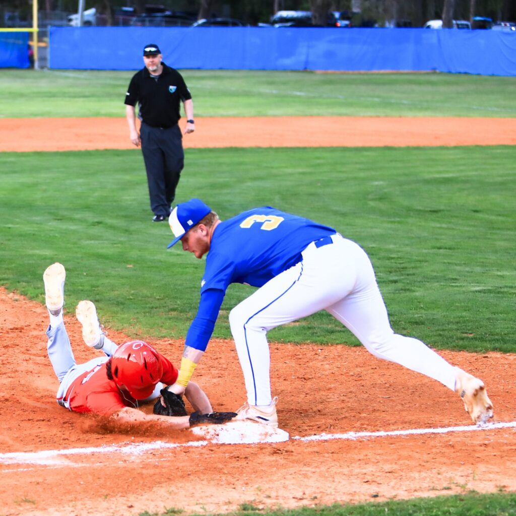 Newberry's Koleby Benson (3) tags out Santa Fe's Brody Rou (15) at third base in the top of the second inning. Photo by C.J. Gish