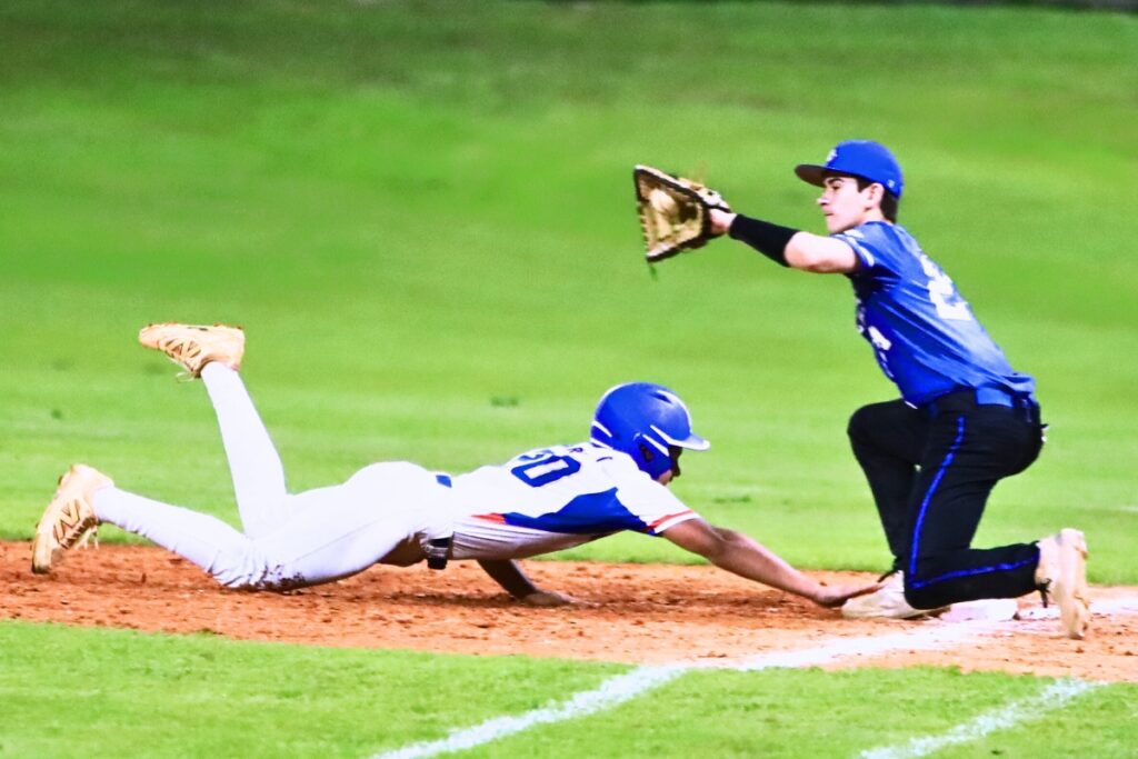 P.K. Yonge's Gerardo Barrios (20) beats the pickoff throw to Saint Francis Catholic first baseman Cyrus Fariborzian (21). Photo by C.J. Gish