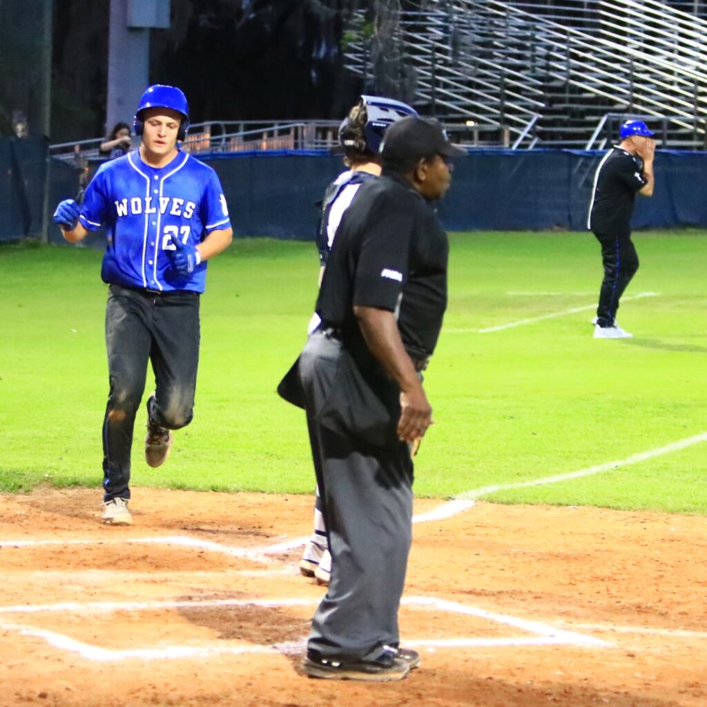 Saint Francis Catholic's Andy Janelle (27) scores the first run of the game in the second inning for a 1-0 lead against P.K. Yonge. Photo by C.J. Gish