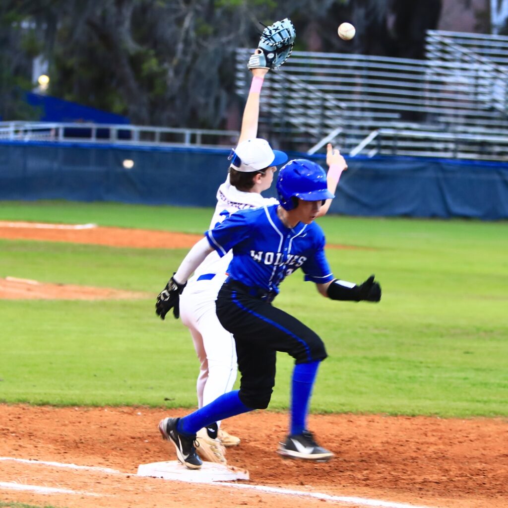 Saint Francis Catholic's Gabe Puentas (3) beats the throw to P.K. Yonge first baseman Tyler Belleville (2). Photo by C.J. Gish