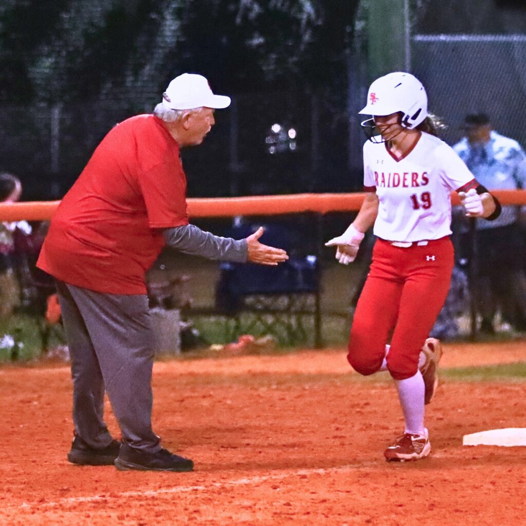 Santa Fe coach Gene Findley congratulates Rylee Swilley (19) on a solo home run that tied the game at 3-3 in the top of the sixth inning at Trenton. Photo by C.J. Gish