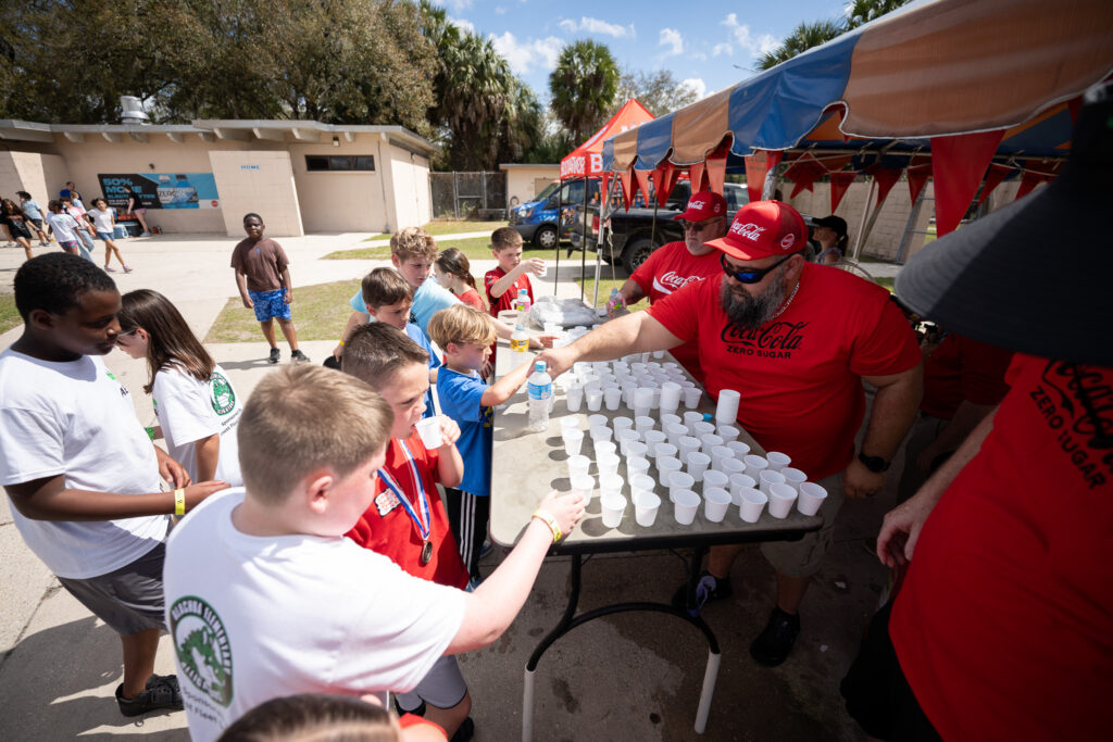 Staff giving students refreshments during the Fifth-Grade Field Day at Citizens Field.