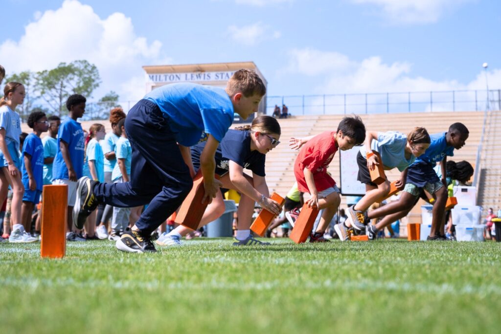Students picking up blocks in the block race for Fifth Grade Field Day at Citizens Field. Photo by Tim Rodriquez