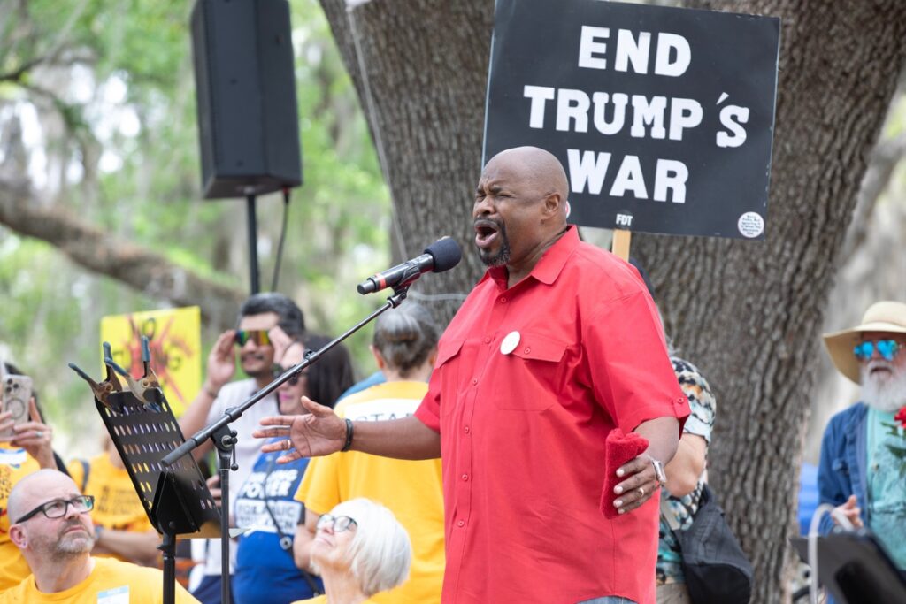 The Rev. Dr. Gary Neal leads the crowd in song Saturday during the No Kings protest at Cora P. Roberson Park in Gainesville. Thousands of people gathered in the park to oppose President Donald Trump’s policies, including those related to immigration, war and the economy.