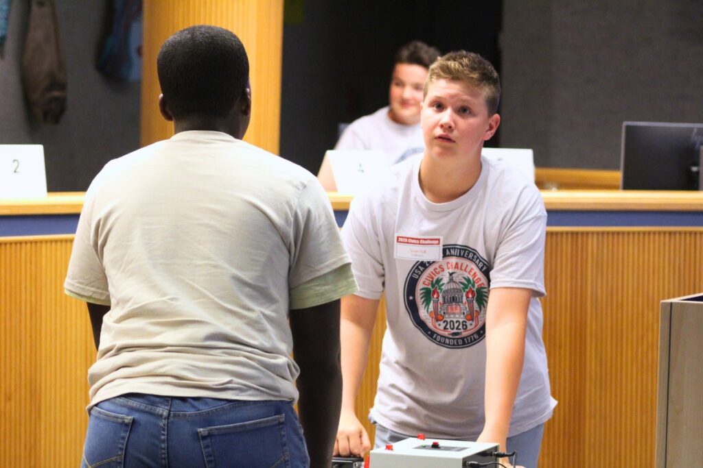 A student looks at a question on the screen before hitting the buzzer to answer. Photo by Nick Anschultz