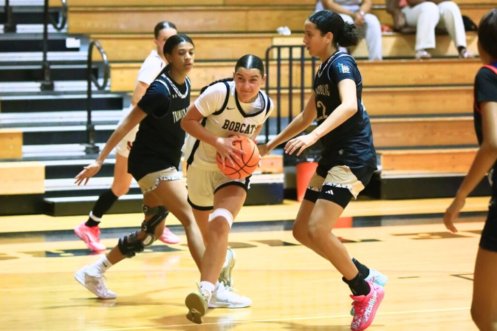 Buchholz's Taylor Booth (12) drives between Trinity Catholic's Ashley Washinton (11) and Jaylyn Valdez (22) at The Prep Zone All-Star Showcase on Saturday. Photo by C.J. Gish