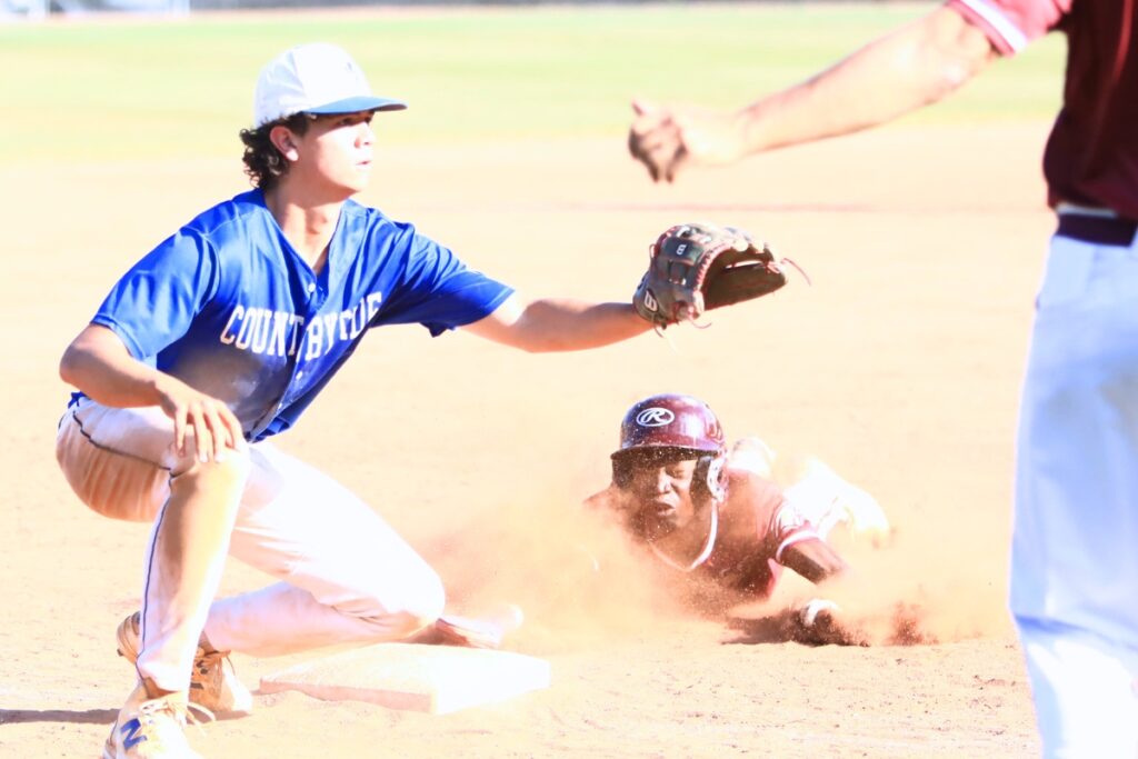 Oak Hall's BJ Johnson slides safely into third base in the bottom of the fourth inning against Countryside Christian's Easton Watson in the Class 1A-District 5 semifinals. Photo by C.J. Gish