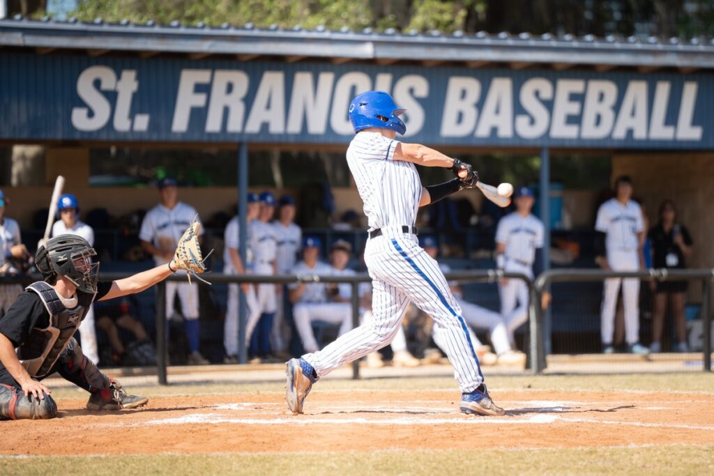 Saint Francis Catholic's Gabe Long (13) hits the ball against Lake Mary Prep in the 1A-Region 2 Quarterfinals. Photo by Tim Rodriquez