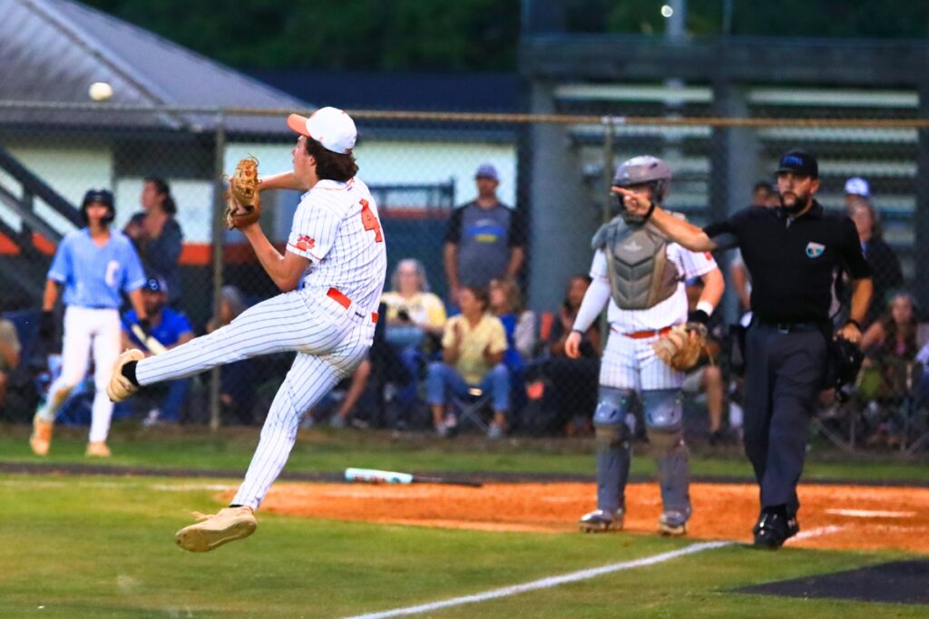 Trenton's Gabriel Cobb (4) tries to throw out Chiefland's Brody Johnson at first base following a successful bunt in the Rural-District 7 semifinals. Photo by C.J. Gish