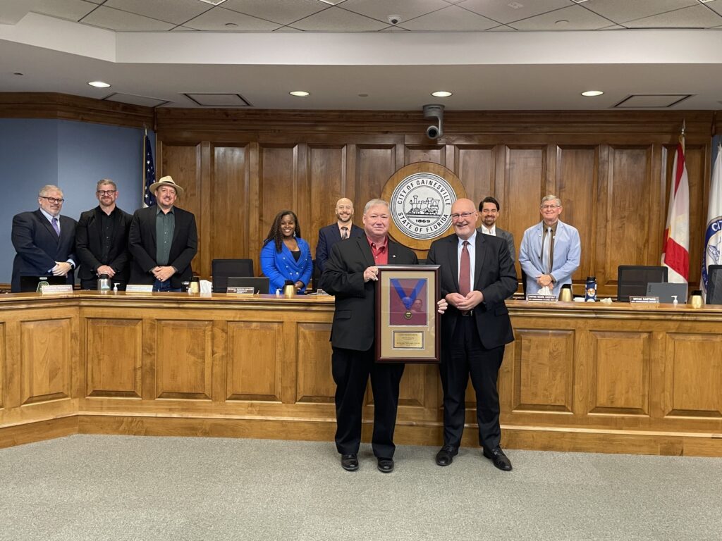 The Gainesville City Commission recognized Phil Mann (front left) at its May 21, 2026, meeting.
