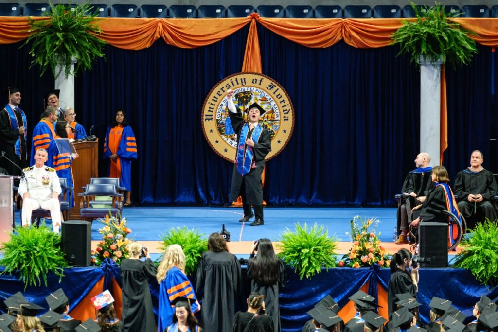 A UF grad raises his fist in victory as he finishes his degree