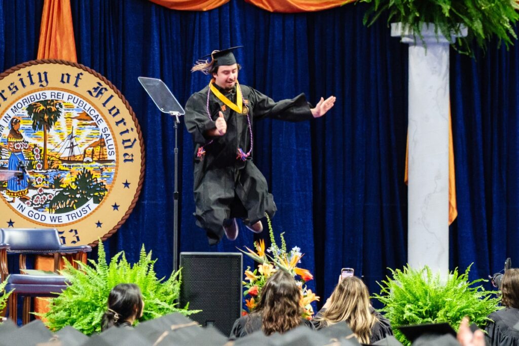 A University of Florida graduate jumps for joy after finishing his degree.