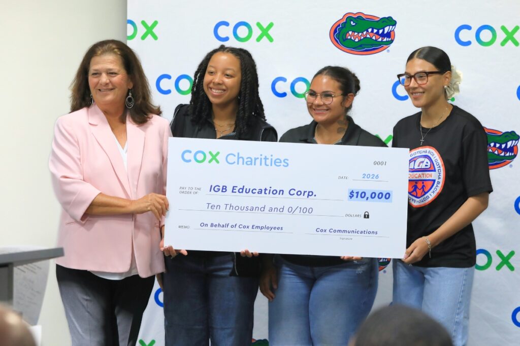Aimee Pfannenstiel, Cox Central Florida market vice president, presents a check to IGB Education Corp. Photo by Seth Johnson
