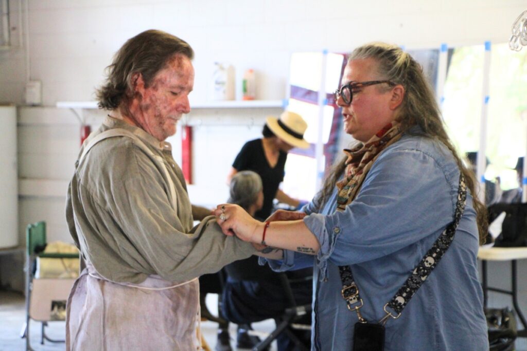 Assistant costume designer M.L. Hart (left) preps cast members for filming. Photo by Lillian Hamman