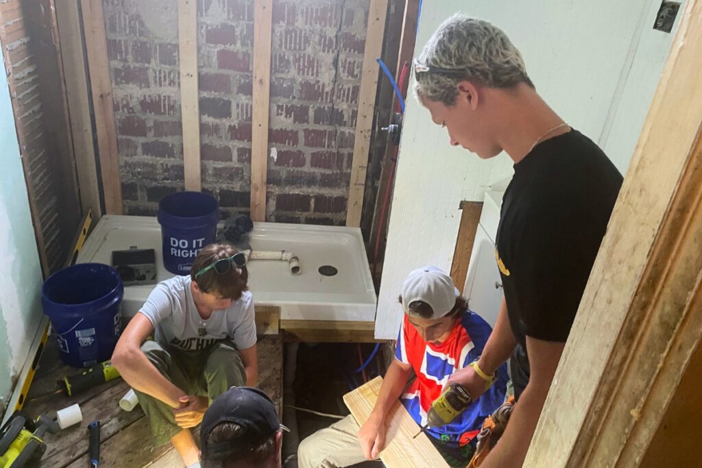 Buchholz High School senior Davis Garrett (front, left) helping with repairs to a home as part of the Appalachia Service Project. Courtesy of Davis Garrett