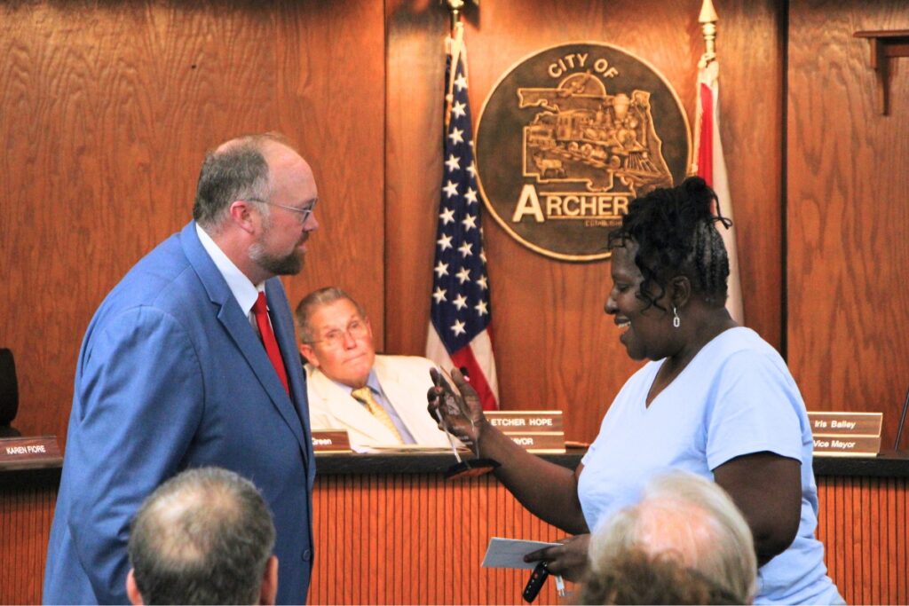 City Manager Donald Barber (left) gives Kath Penny (right) an award as she steps down from the dais. Photo by Lillian Hamman (1)