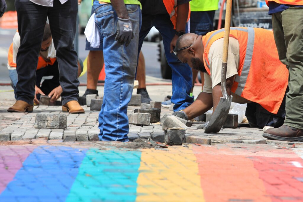Gainesville Public Works employees work to remove bricks used in a rainbow crosswalk and replace them with unpainted bricks. Photo by Seth Johnson