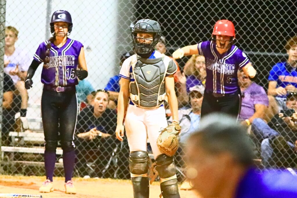 Gainesville's Lana Renicks (15) and Emma Barton (3) score in the sixth inning for a 5-4 lead against Deltona in the 5A-District 5 championship game. Photo by C.J. Gish