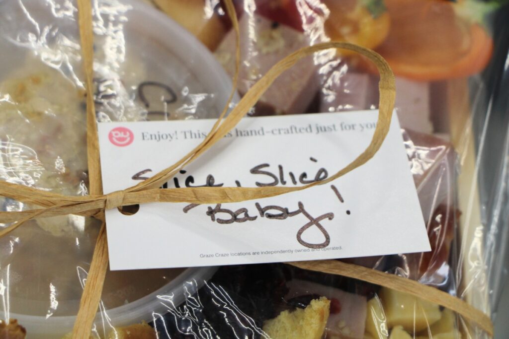 Graze Craze boards are prepared with personalized messages, like this board that says, 'Slice Slice Baby.' 