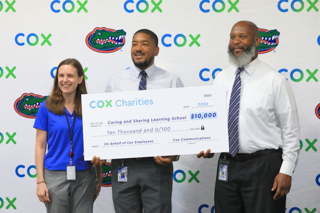 Jaylen Sheppard (center) and Benjamin Hawkins (right) receive the grant for Caring and Sharing Learning School. Photo by Seth Johnson