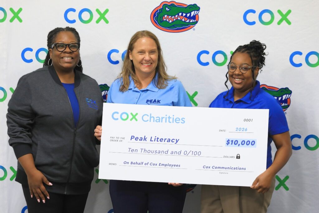 La'Kendra Garrison (left) with Cox Communications presents a check to PEAK Literacy leaders. Photo by Seth Johnson