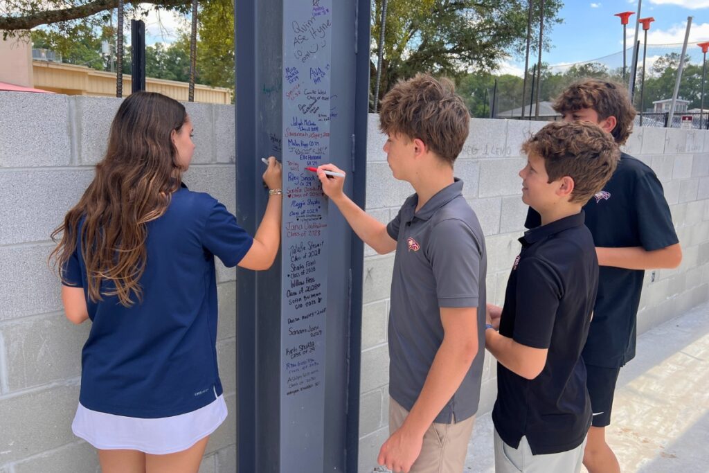 Oak Hall School seventh graders sign their names on a steel beam for the Middle and Upper School gymnasium and training complex. Photo by Nick Anschultz