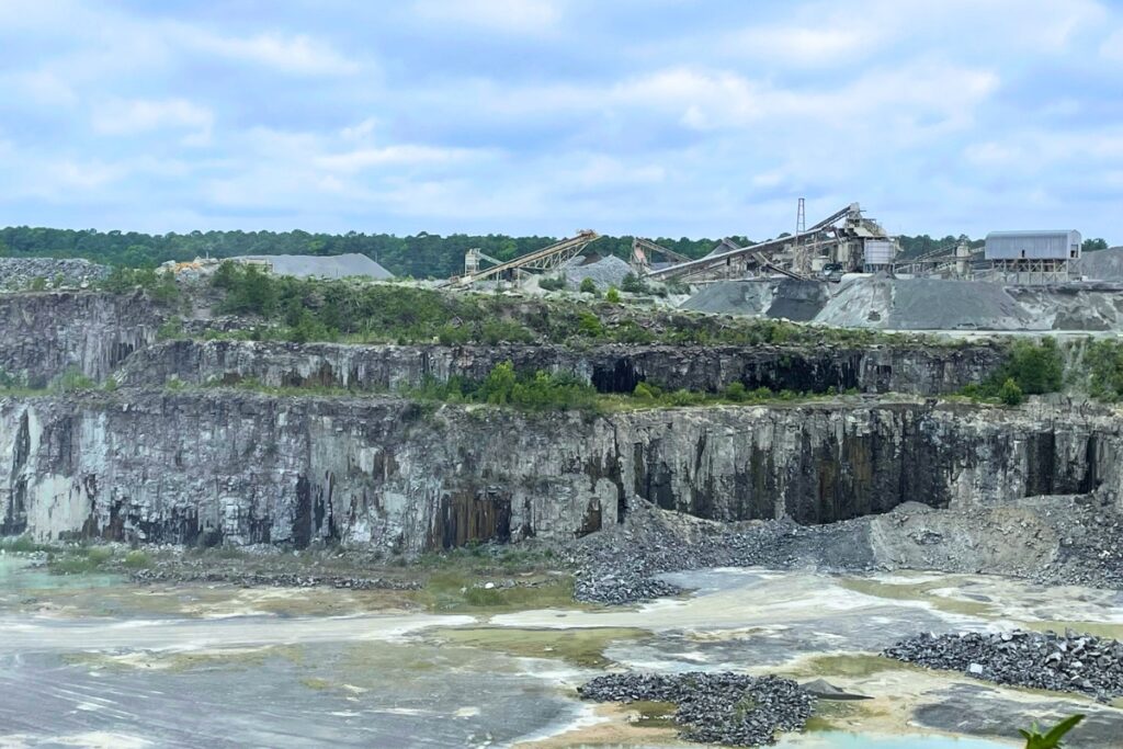 Photo of a quarry in North Carolina of diabase rock, known as basaltic intrusion, with piles of crushed aggregate and fines in the background. Photo by David Foster - UFIFAS