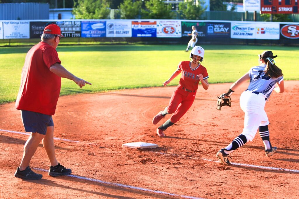 Santa Fe coach Gene Findley waves Maren Hornsby (1) to home in the bottom of the first inning against Eustis in the 3A-Region 2 Final. Photo by C.J. Gish