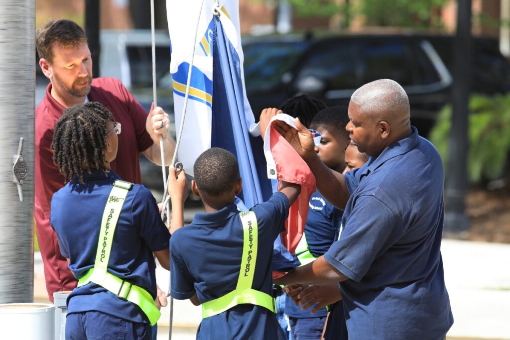 Students from the Caring and Sharing Learning School attach the Juneteenth Flag to the flagpole at City Hall Plaza. Photo by Seth Johnson