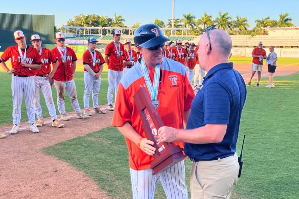 Trenton coach Chris Marlo receives the Rural baseball state runner-up trophy after a close 10-9 loss to Union County on Thursday. Photo by Mike Ridaught