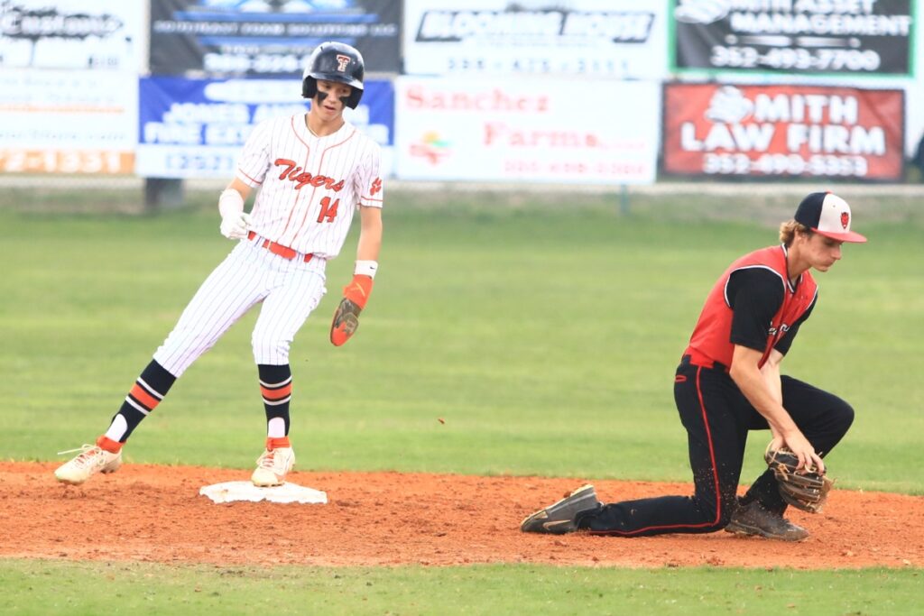 Trenton's Logan Marlo (14) steals second base in the bottom of the first inning against Williston in the first game of the Rural-Region 4 Finals. Photo by C.J. Gish