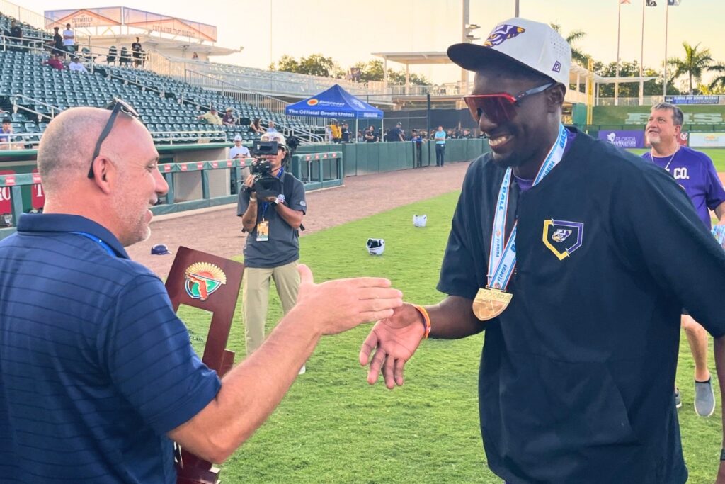 Union County coach Jiwan James (right) accepts the Rural baseball state championship trophy on Thursday. Photo by Mike Ridaught