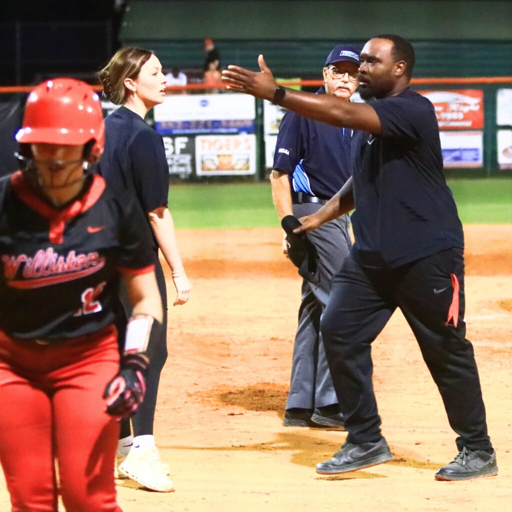 Williston coach Kelcey Coleman (right) argues a third out call that cost the Red Devils two runs in the top of the sixth inning against Trenton in the Rural-Region 4 Final.
