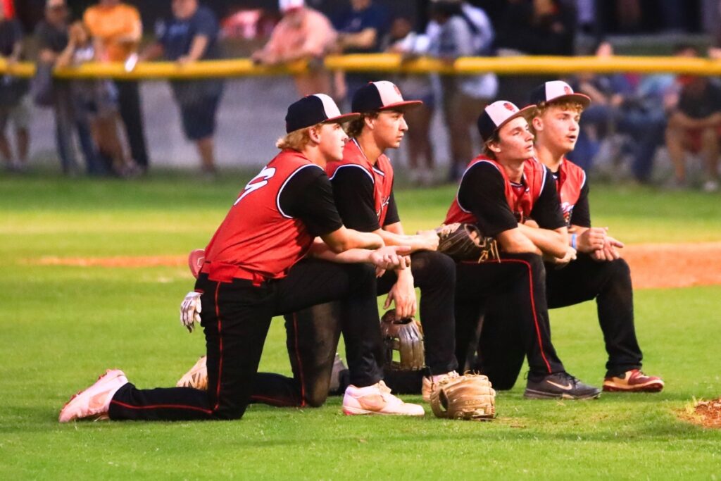 Williston's infielders take a knee during a pitching change in the fourth inning against Trenton in the first game of the Rural-Region 4 Finals. Photo by C.J. Gish