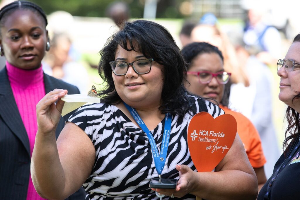 Harminder Kaur-Singh, quality coordinator for HCA Florida North Florida Hospital’s transplant and cellular therapy program, examines a butterfly Friday during the Gainesville hospital’s annual butterfly release ceremony. The event commemorates National Cancer Survivors Month.