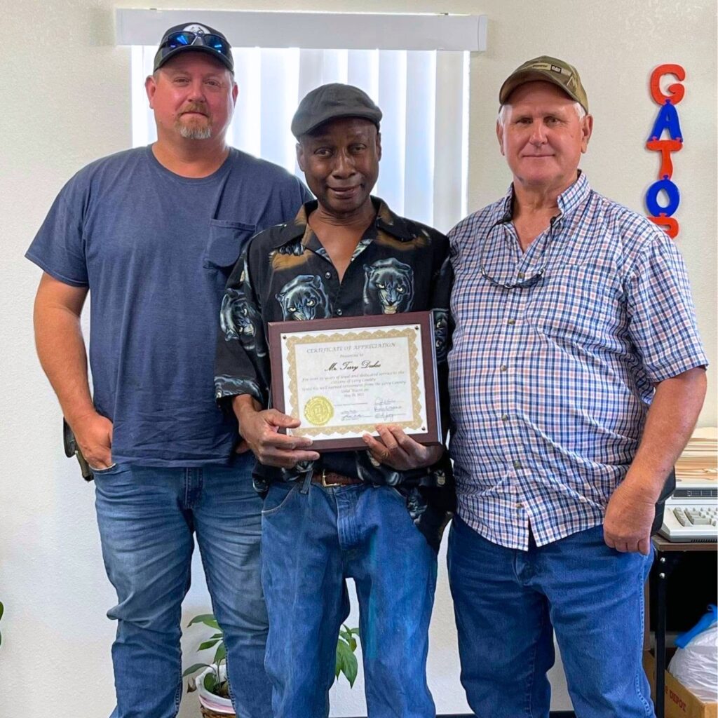 Terry Dukes Sr. (center) received a certificate of appreciation as he retired after 25 years from Levy County Solid Waste Department. Courtesy Levy County