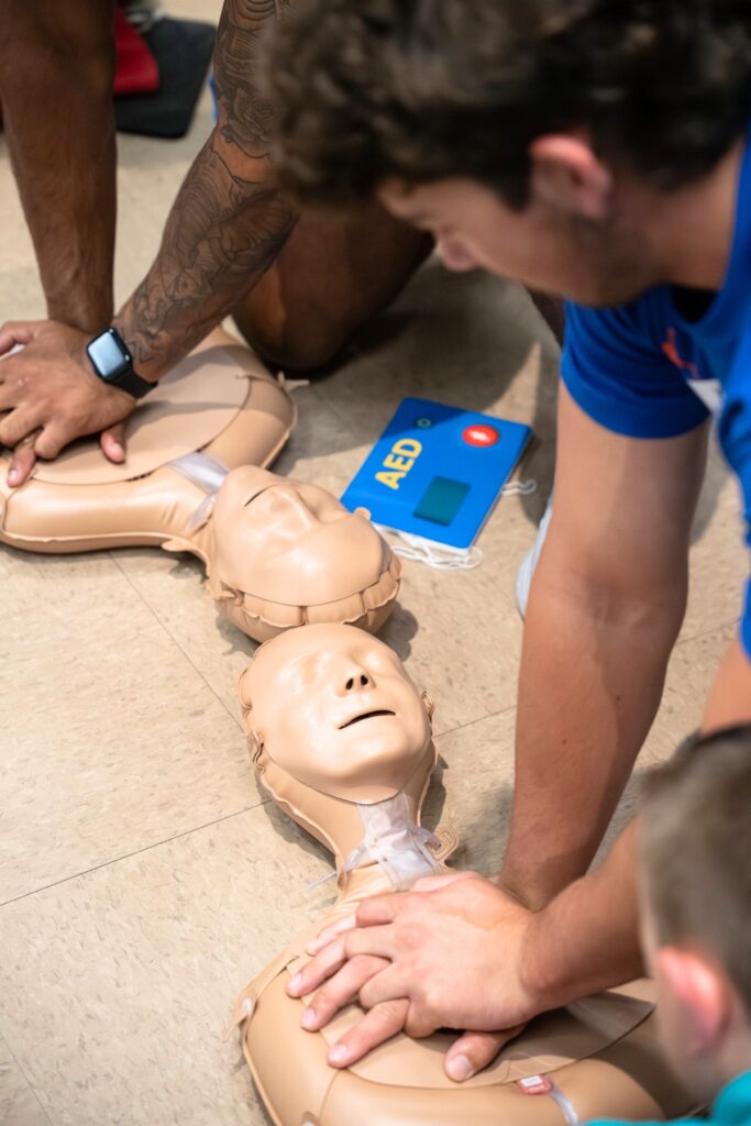 University of Florida Football players demonstrating proper technique to use during when administering CPR. Photo by Tim Rodriqez