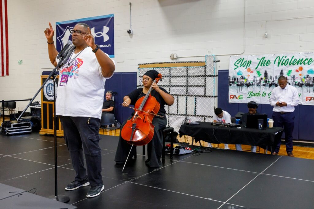 Rev. Karl Anderson speaks during the 27th annual Back to School rally. This year's theme, "Love Shouldn't Hurt," was chosen after local leaders and law enforcement observed an increase in domestic and gun violence. "It's about being proactive, not reactionary," he said.