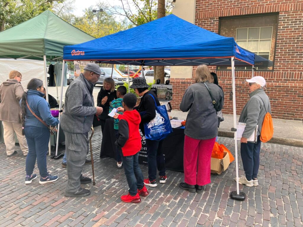 Community members gather around the Crime Stoppers booth at a local event.