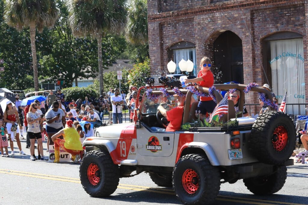 A Jurassic Park Jeep arrives at the end of the parade with lots of bubbles. 