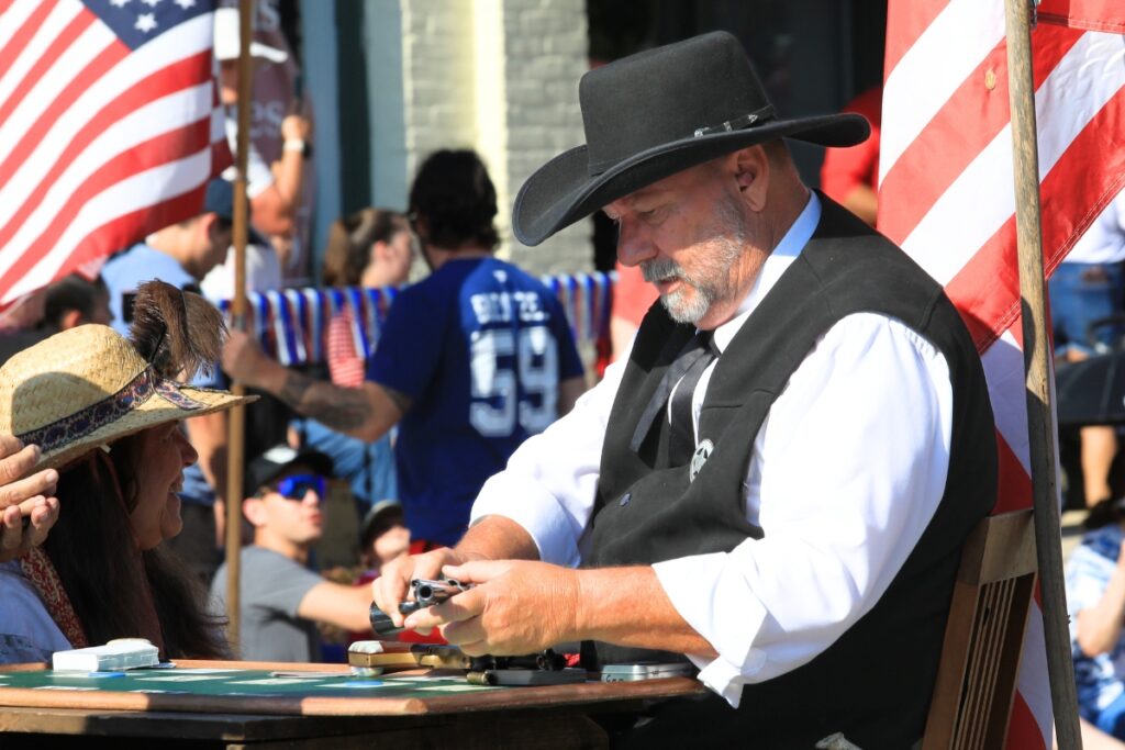 A member of the Shadow Riders reloads his gun after a western showdown in the middle of the parade. 
